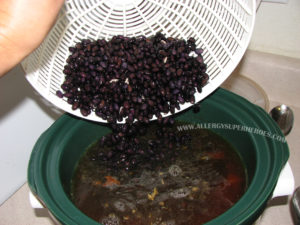 Black beans being poured from colander into crockpot of soup | by Food Allergy Superheroes