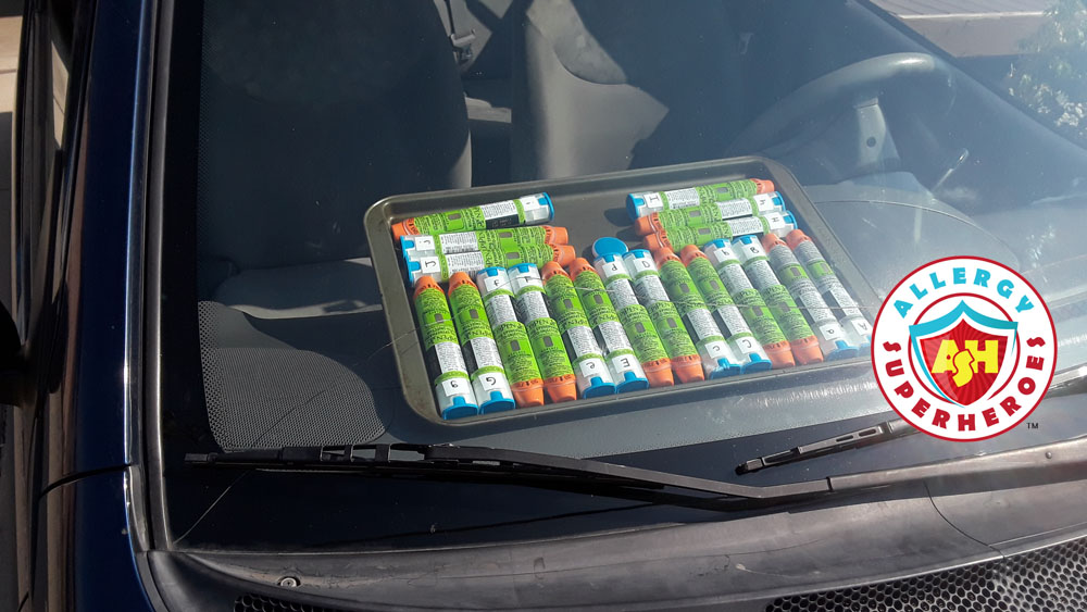 20 EpiPens on a cookie sheet on a car dashboard | by Allergy Superheroes